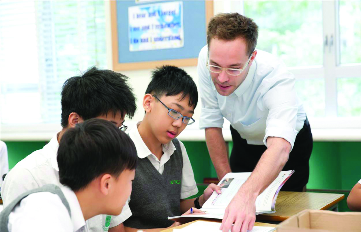a TEFL teacher is helping a group of asian high school students at the desk